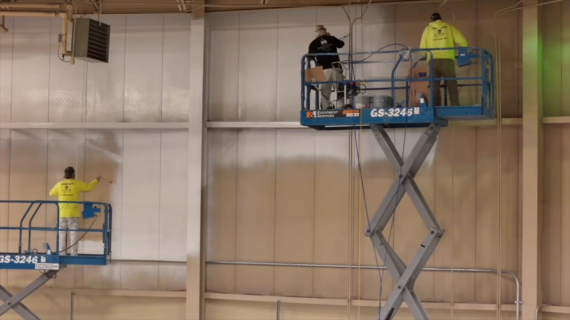 Gardiner crews applying a finish to large interior wall surfaces from elevated work platforms